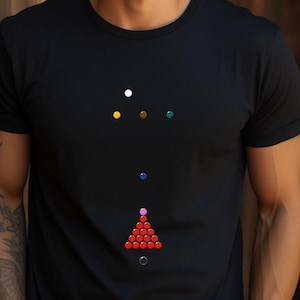 Puede incluir: Una camiseta negra con un diseño de un triángulo de bolas de billar rojas con una bola rosa en la parte superior, y una bola blanca, amarilla, marrón y verde en la parte superior del triángulo.