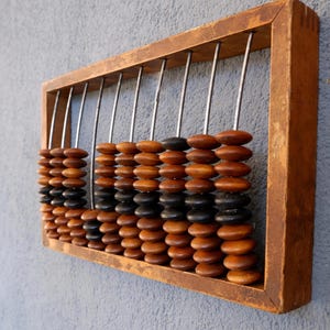 Puede incluir: Un letrero de madera hecho a mano con la palabra "Welcome" en una fuente juguetona. El letrero está pintado de blanco con un acabado envejecido y presenta un pequeño corazón decorativo. Dimensiones aproximadas: 30 cm de ancho y 15 cm de alto.