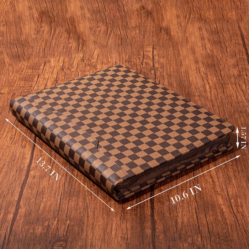 May include: A brown and tan checkered leather portfolio with a zipper closure. The portfolio measures 13.7 inches by 10.6 inches by 1.57 inches.