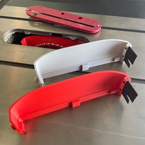 May include: Three table saw accessories, one red, one white and one grey. The accessories are made of plastic and have a black rubber strip on the side. The accessories are designed to be used with a table saw.