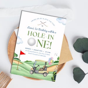 May include: A golf-themed birthday invitation featuring a green and white golf course, a golf buggy, and a golf ball. The text reads "Liam's 1st Birthday will be a Hole-in-One!" with the date and time of the party below.