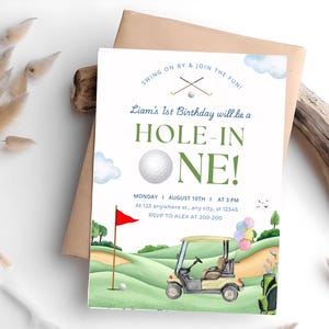 May include: A golf-themed birthday invitation featuring a green and white golf ball, a red flag, a golf buggy, and the text "Liam's 1st Birthday will be a HOLE-IN-ONE!" The invitation also includes the date, time, and RSVP details.