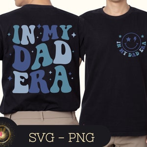 Pode incluir: Camiseta preta com um gráfico azul e branco que diz "In My Dad Era" em uma fonte retrô. O gráfico na parte de trás da camiseta é um rosto sorridente com raios para os olhos e o mesmo texto em um círculo.