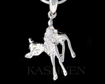 May include: A silver necklace with a crystal-encrusted deer pendant. The deer is standing on its hind legs with its head tilted to the side. The necklace is on a black background.