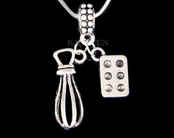 Puede incluir: Collar de plata con un dije de un batidor y una bandeja para hornear. El collar está en una cadena de plata.