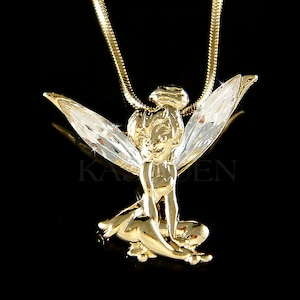 Puede incluir: Un collar con colgante dorado que presenta un dise&ntilde;o de hada con alas claras y brillantes. El hada est&aacute; en posici&oacute;n sentada, con intrincados detalles en la orfebrer&iacute;a dorada. El collar tiene una delicada cadena dorada, ideal como accesorio caprichoso.