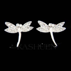 May include: A pair of silver dragonfly earrings with clear crystal accents.