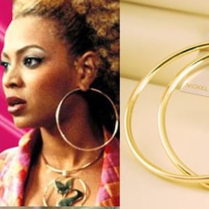 May include: A pair of large, gold-toned hoop earrings. The earrings are made of metal and have a smooth, polished finish. The earrings are nickel-free.