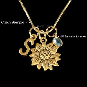 Peut inclure: Collier en or avec un pendentif en forme de tournesol, un pendentif en forme de lettre 'S' et un pendentif en forme de pierre de naissance bleu clair. Le collier est sur une cha&icirc;ne serpent.