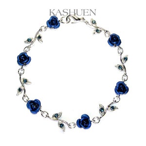 Könnte beinhalten: Ein silbernes Armband mit einer zarten Kette und blauen Rosenanhängern. Das Armband ist mit kleinen Blättern mit klaren Strasssteinen verziert.