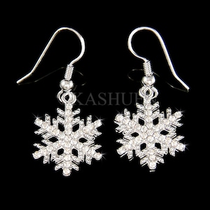 May include: Silver snowflake earrings with clear crystal accents. The earrings have a hook closure.