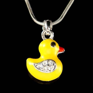 May include: A yellow rubber ducky charm necklace with clear crystal accents. The ducky has a red beak and black eyes.
