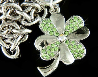 Puede incluir: Encanto de plata con un diseño de trébol de cuatro hojas. El trébol está decorado con diamantes de imitación verdes.