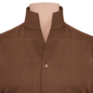 May include: A brown striped shirt with a mandarin collar. The shirt features vertical stripes and a single button. The collar is open at the front, creating a distinctive neckline. The shirt is a classic design.