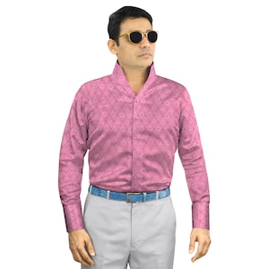 以下が含まれることがあります： ピンク色の長袖シャツ。 幾何学模様が施されています。 シャツはユニークな襟のデザインで、前面にボタンが付いています。 青いベルトとグレーのズボンを着用しています。 サングラスもかけています。