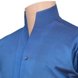 May include: A close-up of a blue shirt with a mandarin collar. The shirt has a single button closure and is made of a smooth, solid-coloured fabric. The collar stands up around the neck.