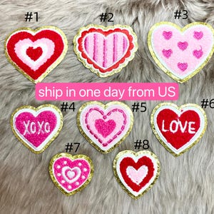 May include: Eight embroidered iron-on patches in the shape of hearts with various designs, including XOXO, LOVE, and hearts with stripes and polka dots. The patches are all outlined in gold.