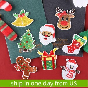 May include: Assortment of colorful embroidered iron-on patches featuring Christmas themes, including a snowman, Santa Claus, a reindeer, a Christmas tree, a gingerbread man, a gift box, and a stocking.  "Merry Christmas to you!" is written on the red background.