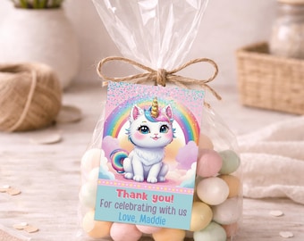 Puede incluir: Una bolsa de plástico transparente llena de caramelos en tonos pastel, atada con un lazo de cuerda marrón. Una etiqueta rectangular muestra un gato unicornio blanco con cuerno dorado, un arcoíris y el texto: Thank you! For celebrating with us Love, Maddie.