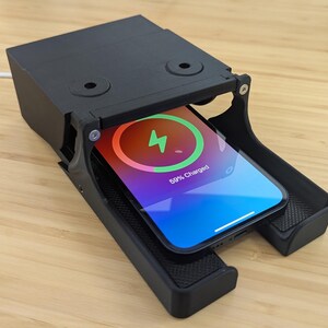 May include: A black wireless charging station with a smartphone inside. The phone screen shows a charging indicator with the text "89% Charged".