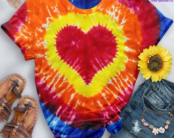 May include: A tie-dye t-shirt with a large red heart in the center. The shirt is a mix of orange, yellow, red, blue, and purple.