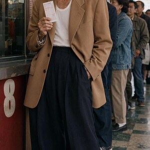 Stylish 80-year-old model wearing an Eat Your Checkers cap while waiting in line with a lottery ticket.