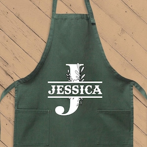May include: A green kitchen apron with a white initial "J" and the name "JESSICA" printed on it.
