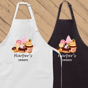 May include: Two white and black aprons with a pocket on each side. The aprons have a colorful graphic of sweets and the text "Harper's Sweets" printed on them.
