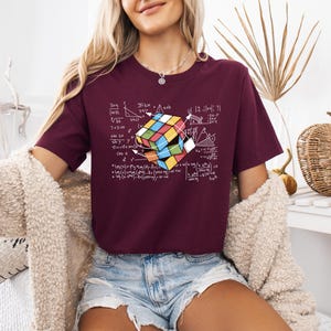 a woman wearing a t - shirt with a rubix cube on it