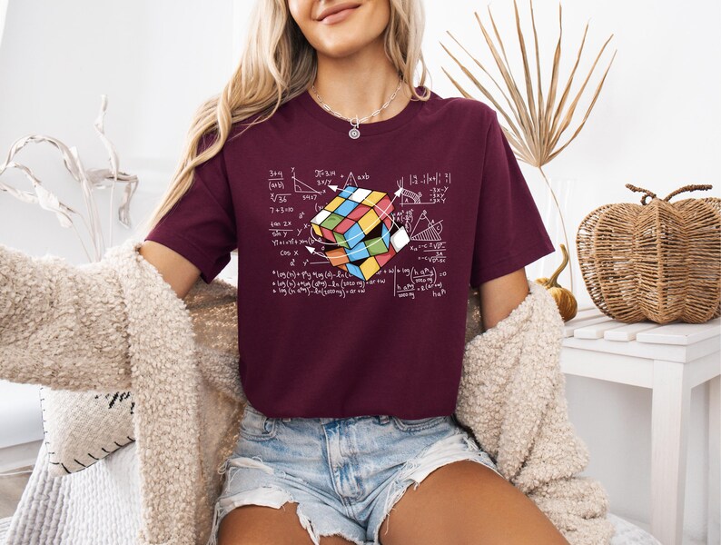 a woman wearing a t - shirt with a rubix cube on it