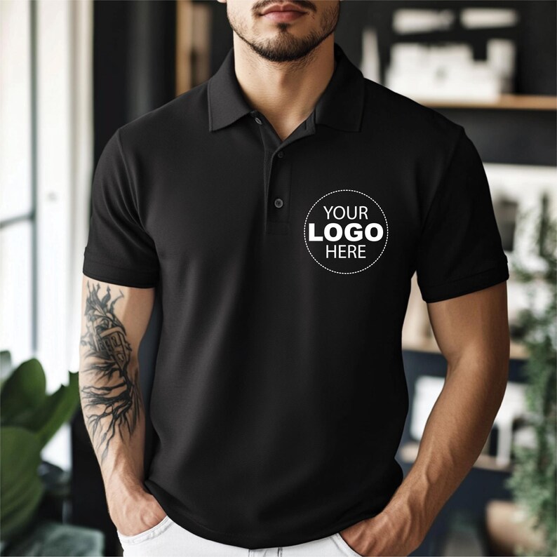A man wearing a black polo shirt with a white logo on the left side of his chest.