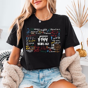 May include: Black t-shirt with a colorful mathematical equation design and the text "√144! YEARS OLD".