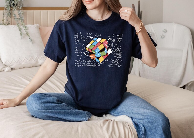 a woman sitting on a bed holding a rubik cube
