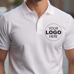 A man wearing a white polo shirt with a logo on the left side of the chest.