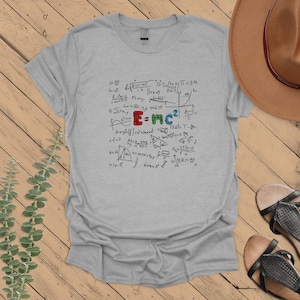 May include: A heather gray t-shirt with a graphic print of various mathematical equations and formulas, including the famous equation "E=mc²".