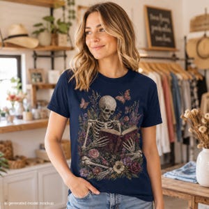 Skeleton reading a book amongst flowers and butterflies on a navy t-shirt mockup.