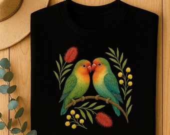 May include: Black crew neck sweatshirt featuring an embroidered design of two colorful lovebirds perched on a branch. The birds have green, orange, and blue plumage, with red accents and yellow floral details.