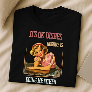 Funny retro housewife T-shirt with 1950s pinup art and a cheeky quote perfect for sarcastic women with better things to do than dishes.