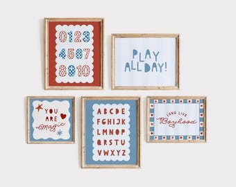 Puede incluir: Cinco impresiones artísticas enmarcadas con marcos de madera. Las impresiones presentan números, el alfabeto y frases como "Play All Day!" y "You Are Magic" en rojo y azul sobre un fondo blanco. Las impresiones tienen un estilo lúdico y caprichoso.
