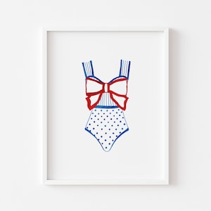 May include: A white swimsuit with a blue and white striped bodice and a red bow. The bottom of the swimsuit is covered in blue polka dots.