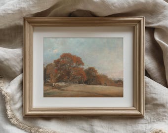 Puede incluir: Lámina artística enmarcada que representa una serena escena otoñal. La obra de arte representa un campo con árboles en tonos naranja y marrón bajo un cielo azul pálido. La impresión está enmarcada en un marco de madera marrón claro.
