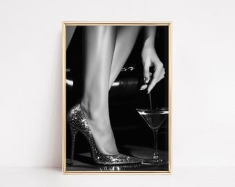 May include: Black and white framed print featuring a high-heeled shoe covered in glitter, a martini glass, and a hand with a ring. The image has a glamorous, vintage aesthetic.