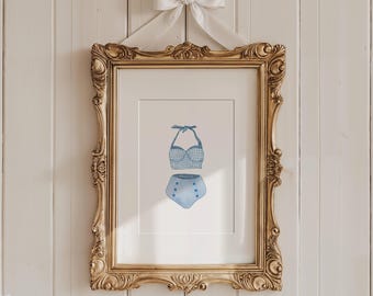 May include: A framed illustration of a blue and white gingham swimsuit with white buttons. The swimsuit is a halter top and high-waisted bottoms.