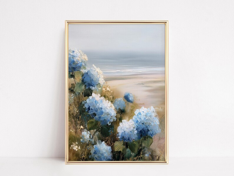 May include: A framed painting featuring a coastal landscape with blue hydrangea flowers in the foreground. The artwork has a gold frame and depicts a beach scene with a soft, muted color palette, evoking a sense of tranquility.