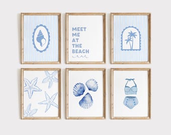 May include: Set of six blue and white framed prints with nautical themes. The prints feature seashells, starfish, palm trees, and a swimsuit. One print says "Meet me at the beach".