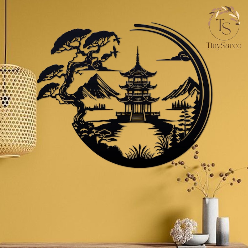 K&ouml;nnte beinhalten: Schwarze Wandkunst aus Metall, die eine japanische Pagode, Berge, B&auml;ume und einen See darstellt. Die Kunst ist kreisf&ouml;rmig und hat ein minimalistisches Design.