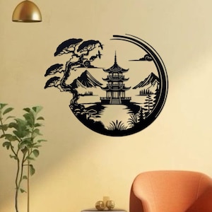 K&ouml;nnte beinhalten: Schwarze Silhouette Wandkunst mit einer Pagode, Bergen und einem Baum in einem kreisf&ouml;rmigen Design. Das Kunstwerk ist vor einer hellbeigen Wand platziert.