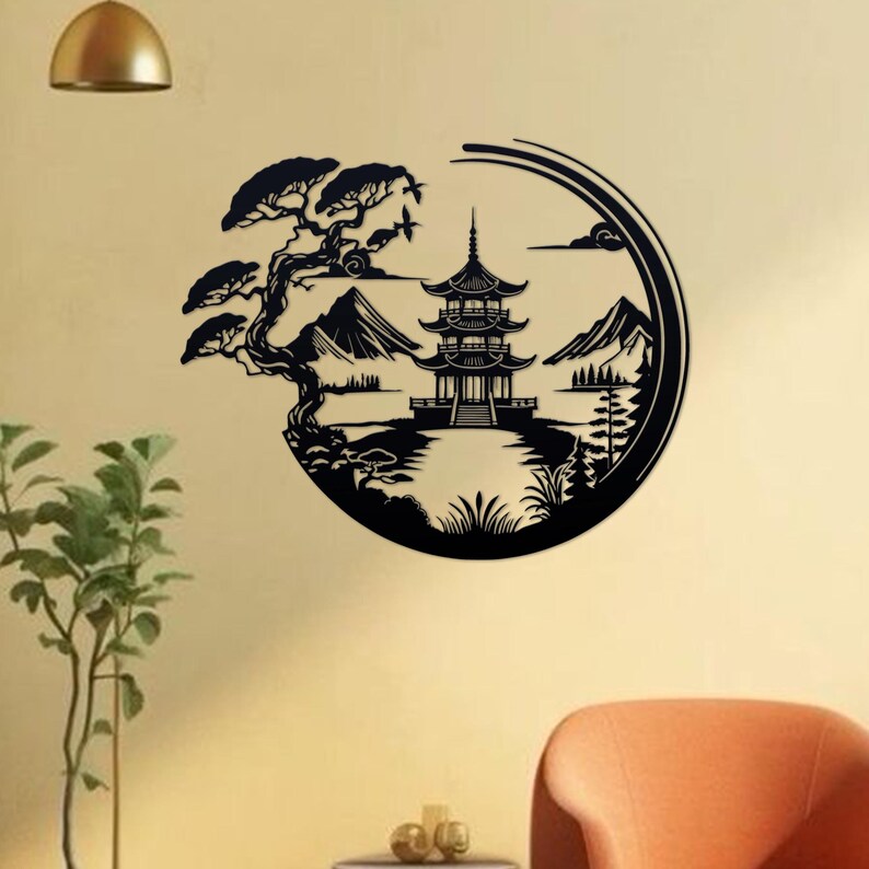 K&ouml;nnte beinhalten: Schwarze Silhouette Wandkunst mit einer Pagode, Bergen und einem Baum in einem kreisf&ouml;rmigen Design. Das Kunstwerk ist vor einer hellbeigen Wand platziert.