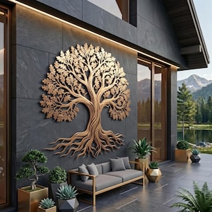 Könnte beinhalten: Eine große, filigrane Wandskulptur aus goldfarbenem Metall, die einen Baum mit weit verzweigten Wurzeln und detaillierten Blättern darstellt, montiert an einer dunkelgrauen Steinaußenwand über einem grauen Outdoor-Sofa und Pflanzen.