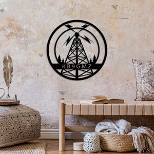 May include: Black metal wall art featuring a stylized radio tower with lightning bolts and trees. The call sign "KB9GMZ" is displayed below the tower.
